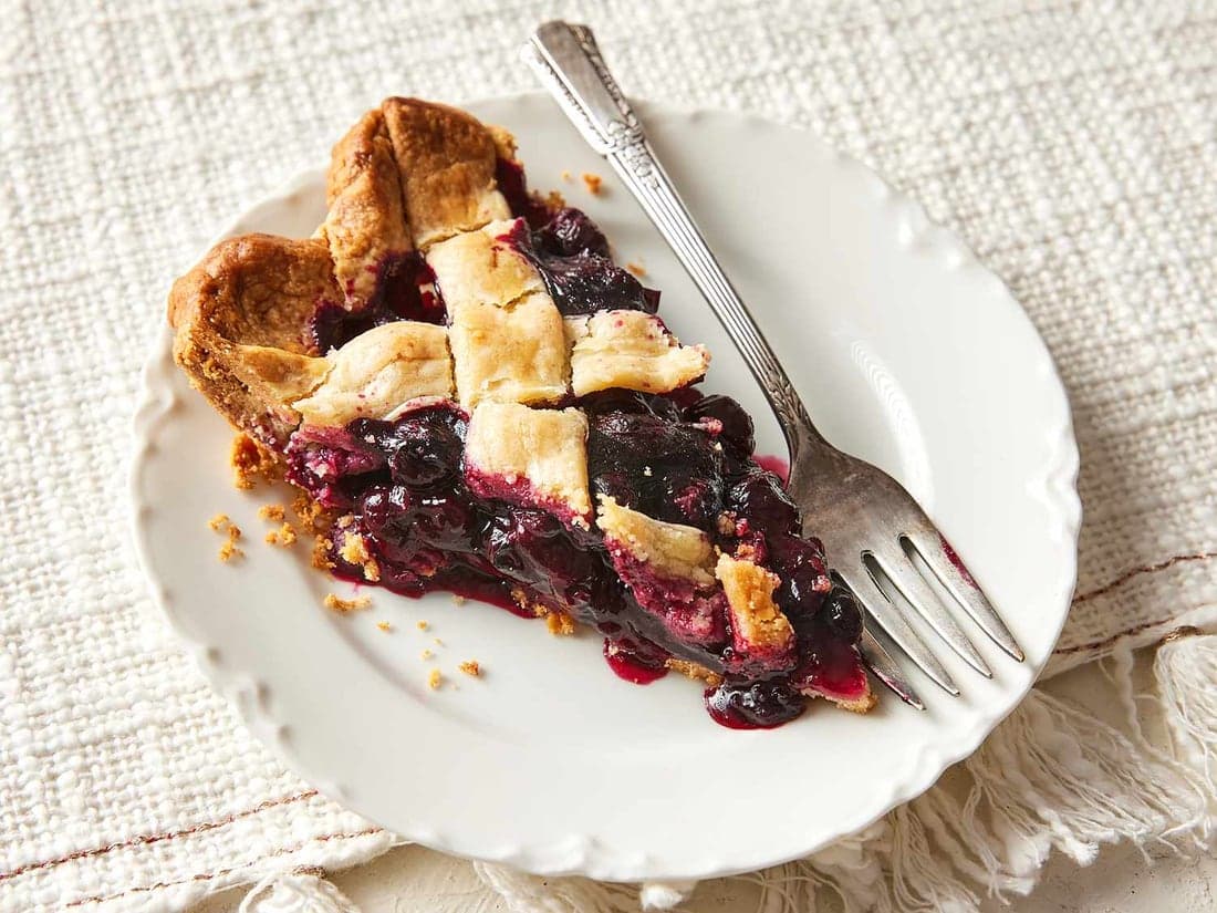 A blueberry pie with a slice taken out